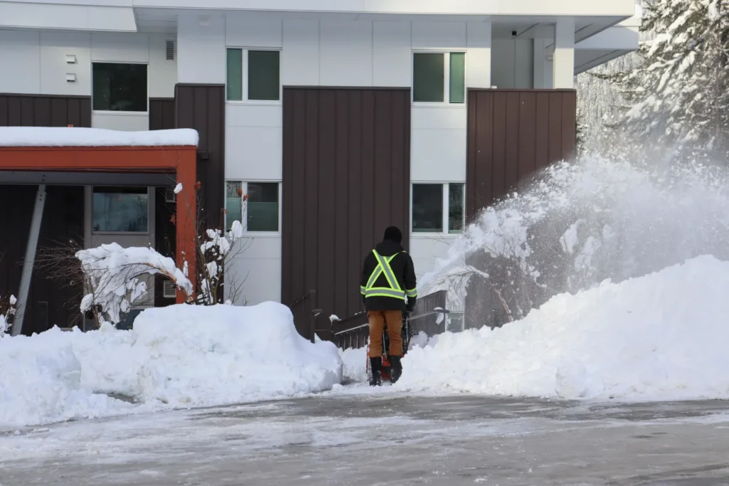 man clearing snow with a snow blower