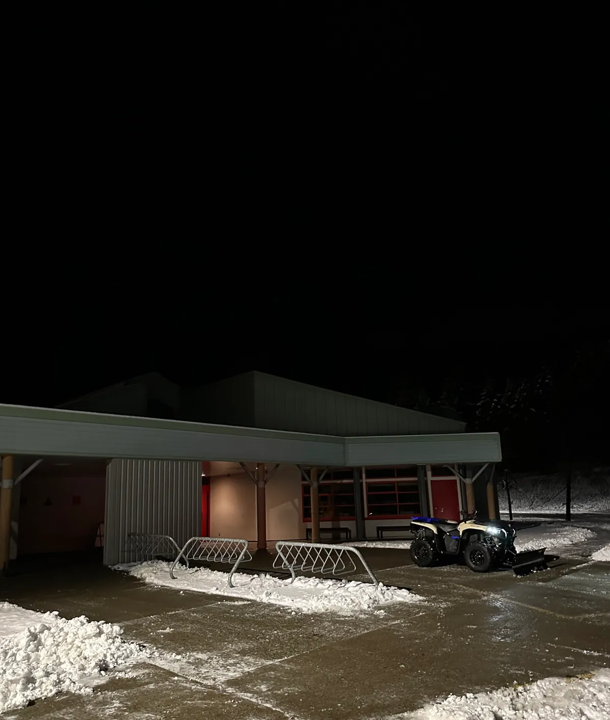 ATV with snowplow, clearing a school walkway